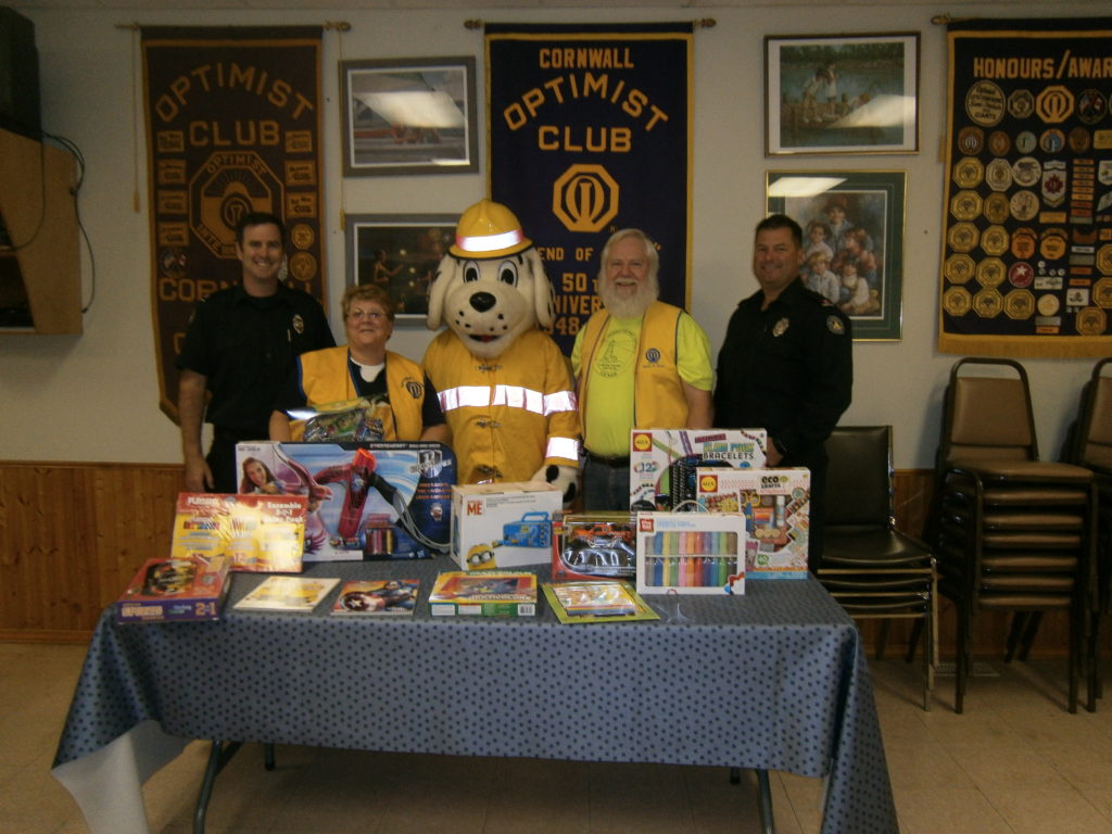 Left to right: Firefighter  Ian Robertson, Toy Drive Chair  Anita Tremblay,   Sparky, Optimist President  Ralph Brunton, Captain James McDonald